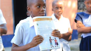 A school boy reading the toolkit for Very Young Adolescents (VYA) that contains information about Sexual and Reproductive Health (SRH)